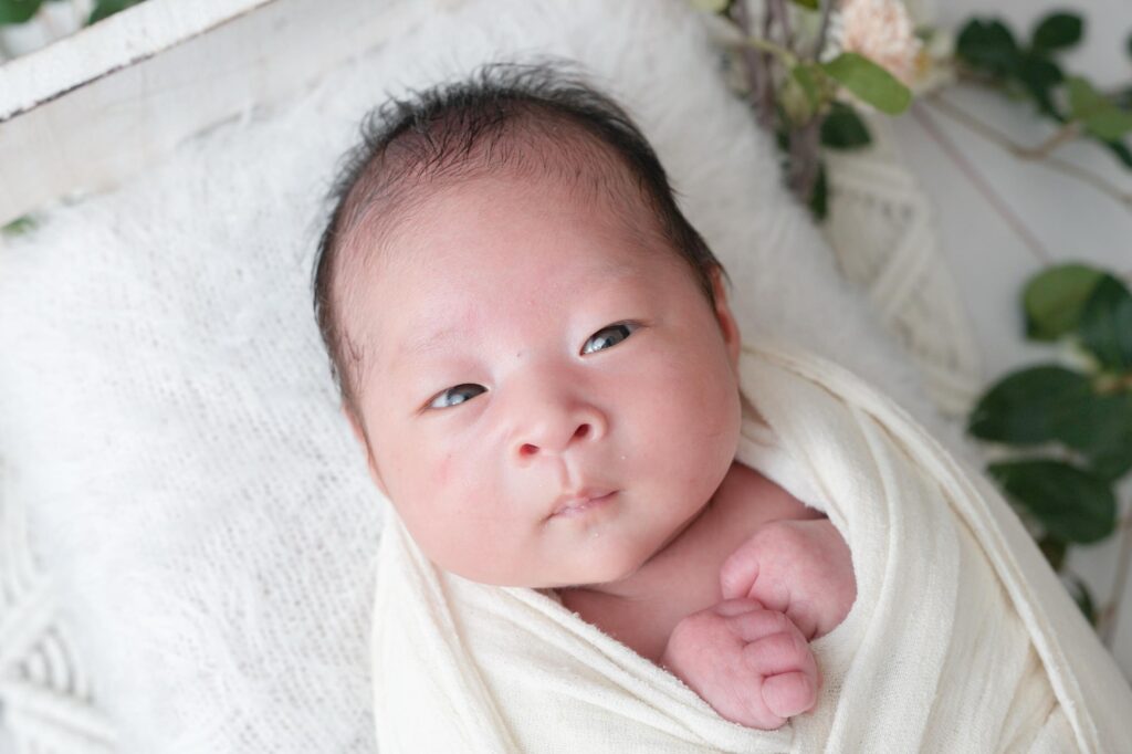 安曇野市でのニューボーンフォト｜白いおくるみを巻いてカメラ目線の赤ちゃんの写真