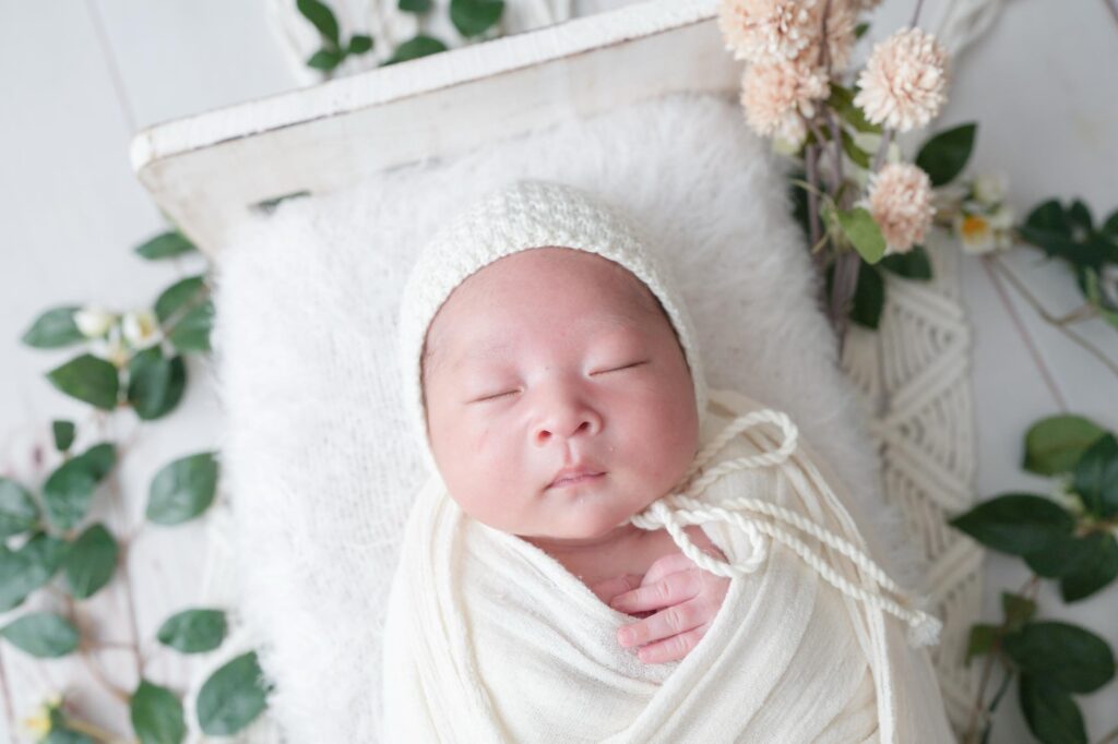 安曇野市でのニューボーンフォト｜白いおくるみにシンプルな帽子をかぶった赤ちゃんの写真